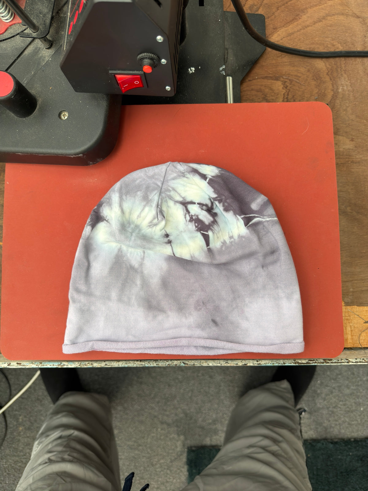 Hand-dyed beanie: light grey with pale cream upper patches and dark marking upper-right.