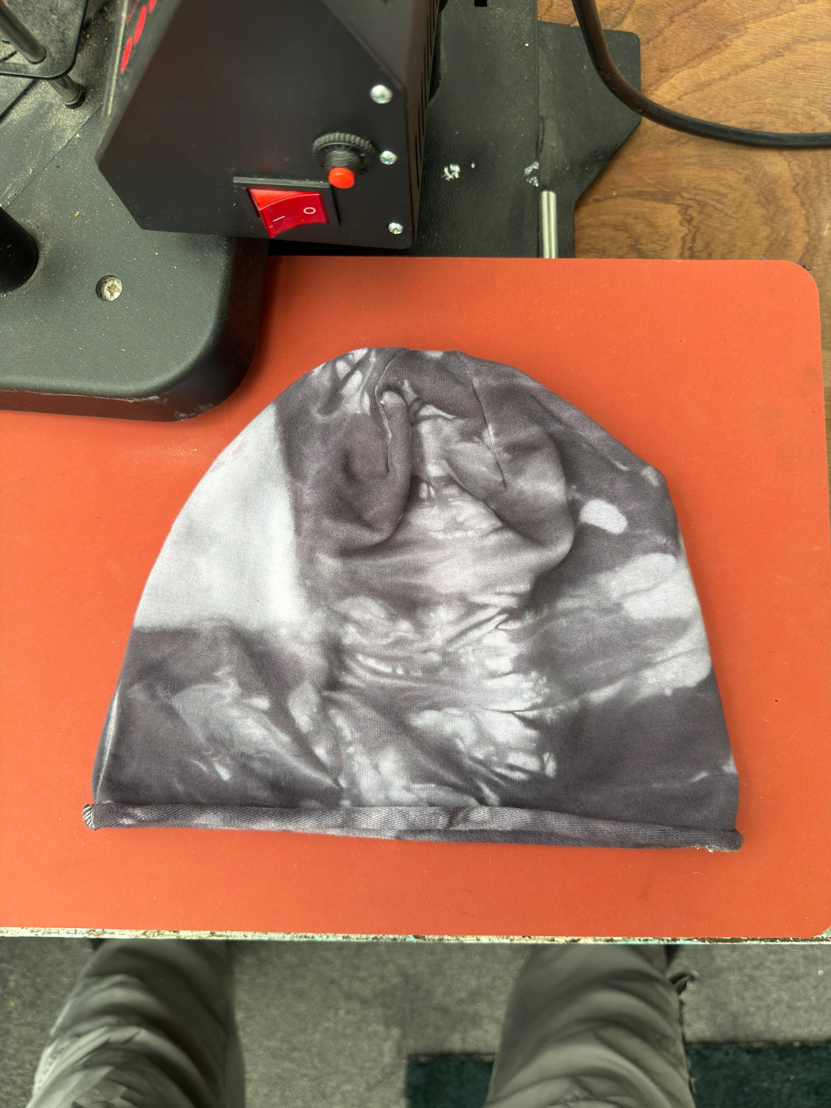 Hand-dyed beanie: dark grey with white/light swirling bands and pale left area.